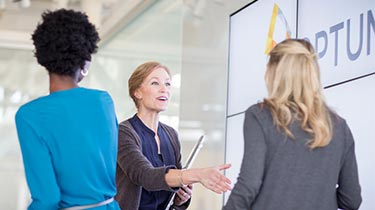 Woman welcoming to business women at Optum event