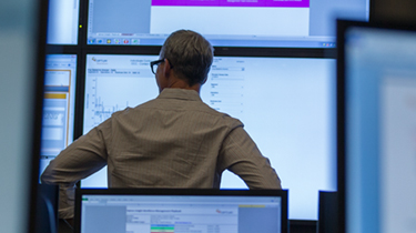 Information technology staff member looking at monitors